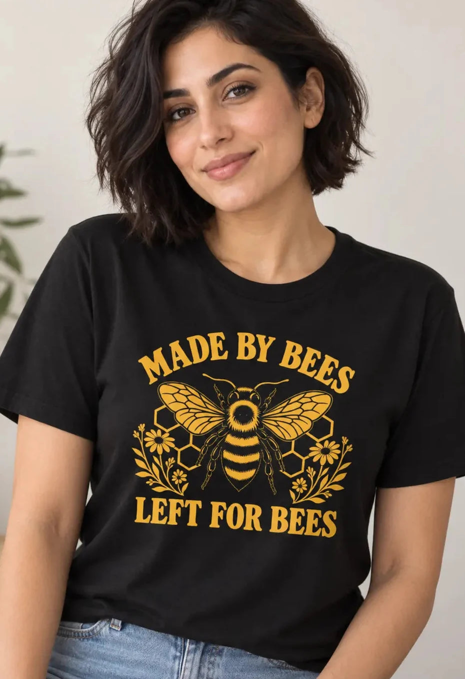 Woman wearing a black t-shirt with a bee image and text 'made by bees, left for bees vegan t-shirt