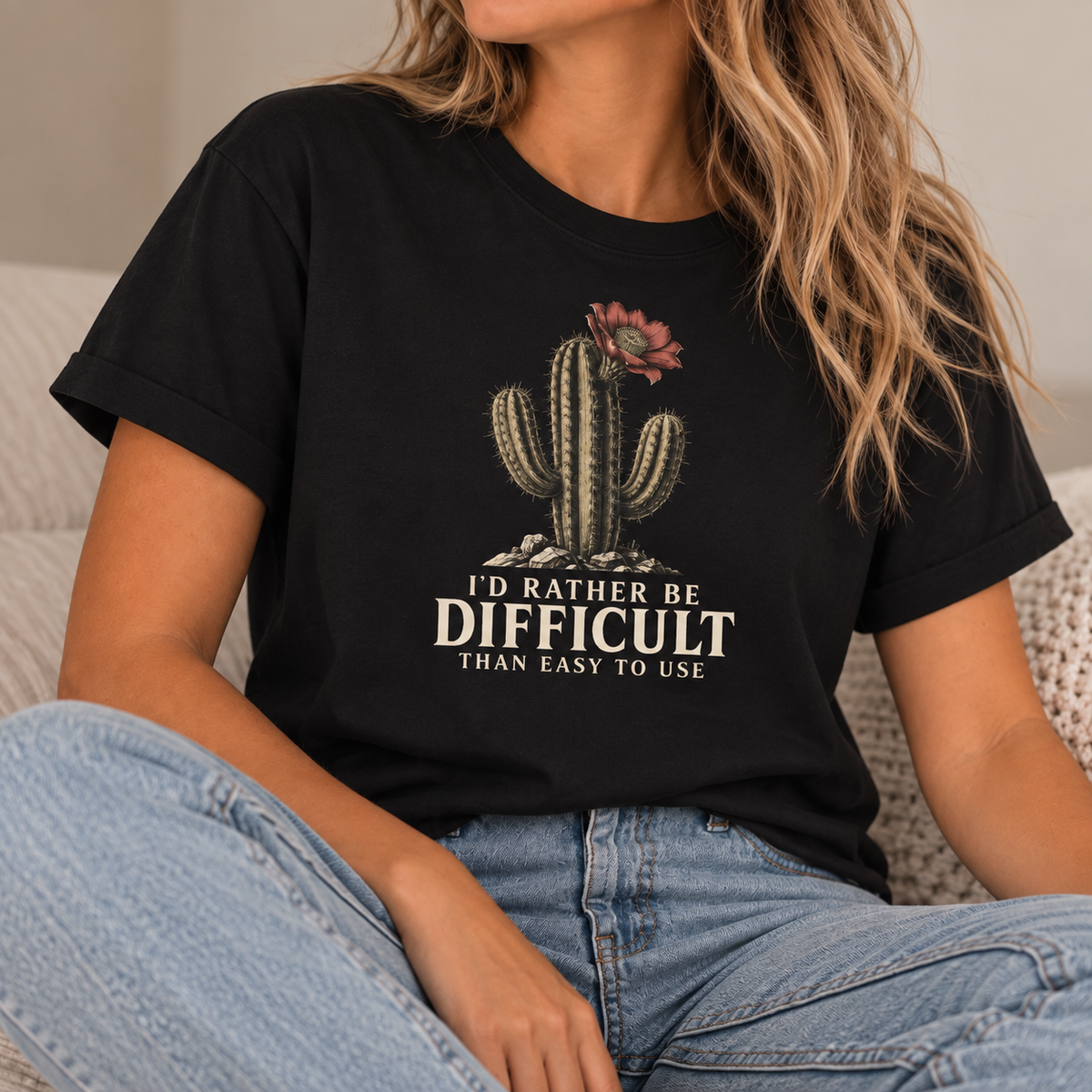 Woman wearing a black t-shirt with a cactus graphic and text 'id rather be difficult than easy to use'