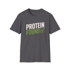 A dark gray crewneck t-shirt with a graphic on the chest that reads 'PROTEIN FOUND' in white and green, with a checkmark inside a green box, shown on a plain white background.