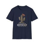 Navy blue short-sleeve crewneck t-shirt featuring a graphic of a cactus with a flower and the text 'I'D RATHER BE DIFFICULT THAN EASY TO USE' printed on the front, displayed against a solid white background.