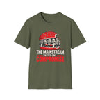 An olive green short-sleeve t-shirt with a graphic of a burger featuring multiple faces and the text 'THE MAINSTREAM TASTES LIKE COMPROMISE' in white and red, displayed on a solid white background.