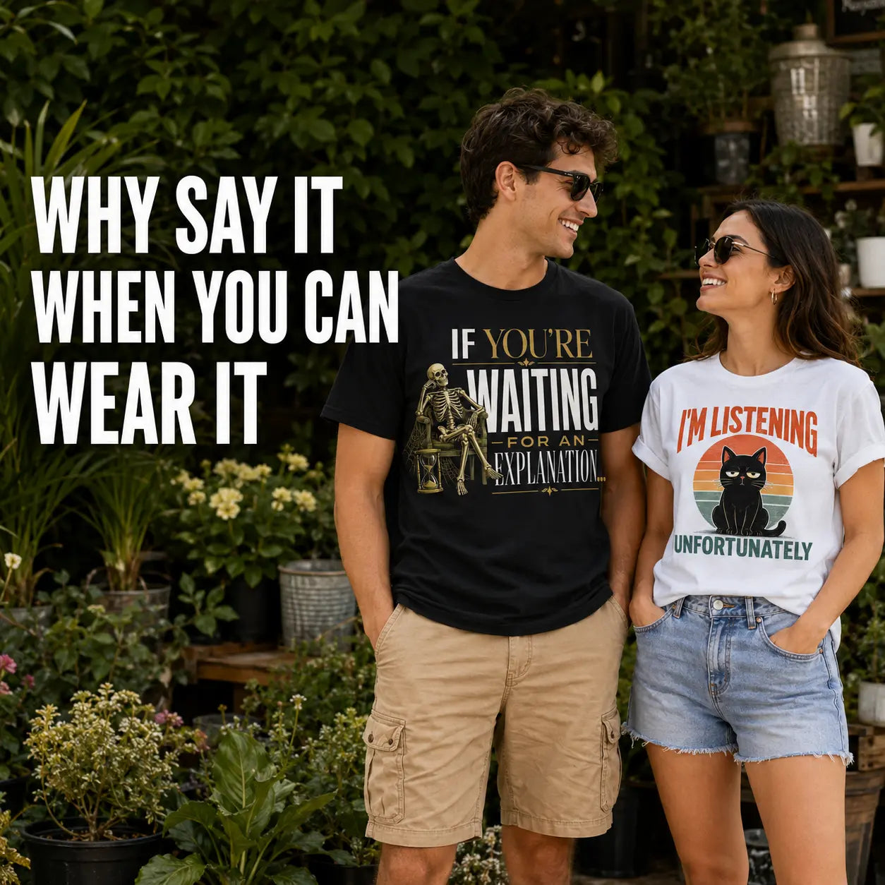 A man and a woman standing in a garden wearing graphic t-shirts. The man wears a black t-shirt with a skeleton and the text 'IF YOU'RE WAITING FOR AN EXPLANATION'.