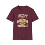 maroon graphic t-shirt with an image of a tub of hummus and text 'emotionally supported by hummus' on a wooden board with jeans and sneakers
