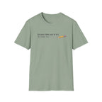 A sage green short-sleeve crewneck t-shirt with a graphic on the chest that reads 'TOO WEAK FROM LACK OF B12 TO FINISH THIS SLOGAN' next to a small yellow pencil illustration, shown on a plain white background.