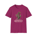 Hot pink short-sleeve crewneck t-shirt featuring a graphic of a cactus with a flower and the text 'I'D RATHER BE DIFFICULT THAN EASY TO USE' printed on the front, displayed against a solid white background.