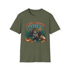 An olive green short-sleeve crewneck t-shirt featuring a cartoon graphic of a gorilla wearing sunglasses and holding a banana, with the text 'PROTEIN DEFICITY SURVIVOR' above it.