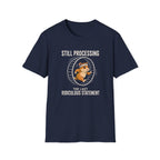 Navy blue short-sleeve t-shirt with a graphic of a cartoon beaver running inside a large exercise wheel, accompanied by the text 'STILL PROCESSING THE LAST RIDICULOUS STATEMENT'.