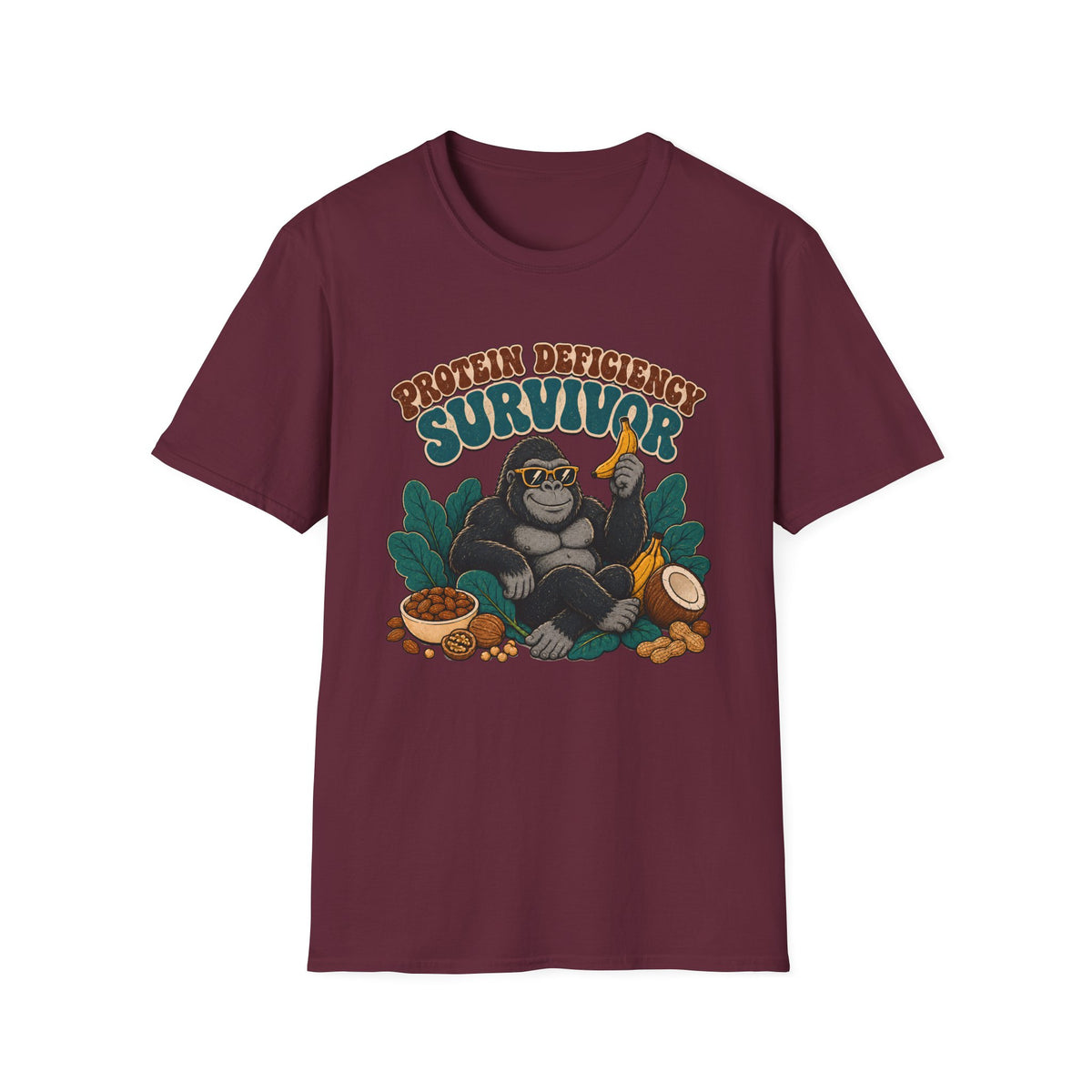 A maroon short-sleeve crewneck t-shirt featuring a graphic of a gorilla wearing sunglasses and holding a banana, surrounded by tropical leaves, nuts, and a bowl, with the text 'PROTEIN DEFICITY SURVIVOR' above it.