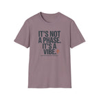 A short-sleeve crewneck t-shirt in a muted dusty mauve color, featuring the text 'IT'S NOT A PHASE. IT'S A VIBE.