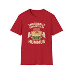 red graphic t-shirt with an image of a tub of hummus and text 'emotionally supported by hummus' on a wooden board with jeans and sneakers