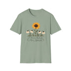 Green graphic T-shirt featuring a bright yellow sunflower above four drooping cream flowers with I Wasn't Made for Mass Approval in cursive text.