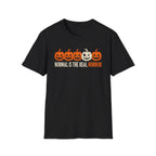 Black Graphic T-shirt design featuring five jack-o’-lanterns, with one white mismatched pumpkin standing out from four orange pumpkins, above the words “Normal Is the Real Horror.”