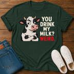 A dark green short-sleeve crewneck t-shirt featuring a graphic of a cartoon cow with crossed arms next to the text 'YOU DRINK MY MILK? WEIRD.' in cream and red lettering, shown on a plain white background.
