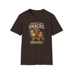 A dark brown short-sleeve t-shirt with a vintage-style graphic of a raccoon holding various snacks, with the text 'I BROUGHT MY OWN SNACKS OBVIOUSLY.' printed on the front.