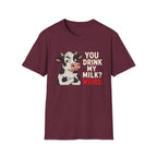 A maroon short-sleeve crewneck t-shirt featuring a graphic of a black and white cow next to the text 'YOU DRINK MY MILK? WEIRD.' in cream and red lettering, displayed on a solid white background.