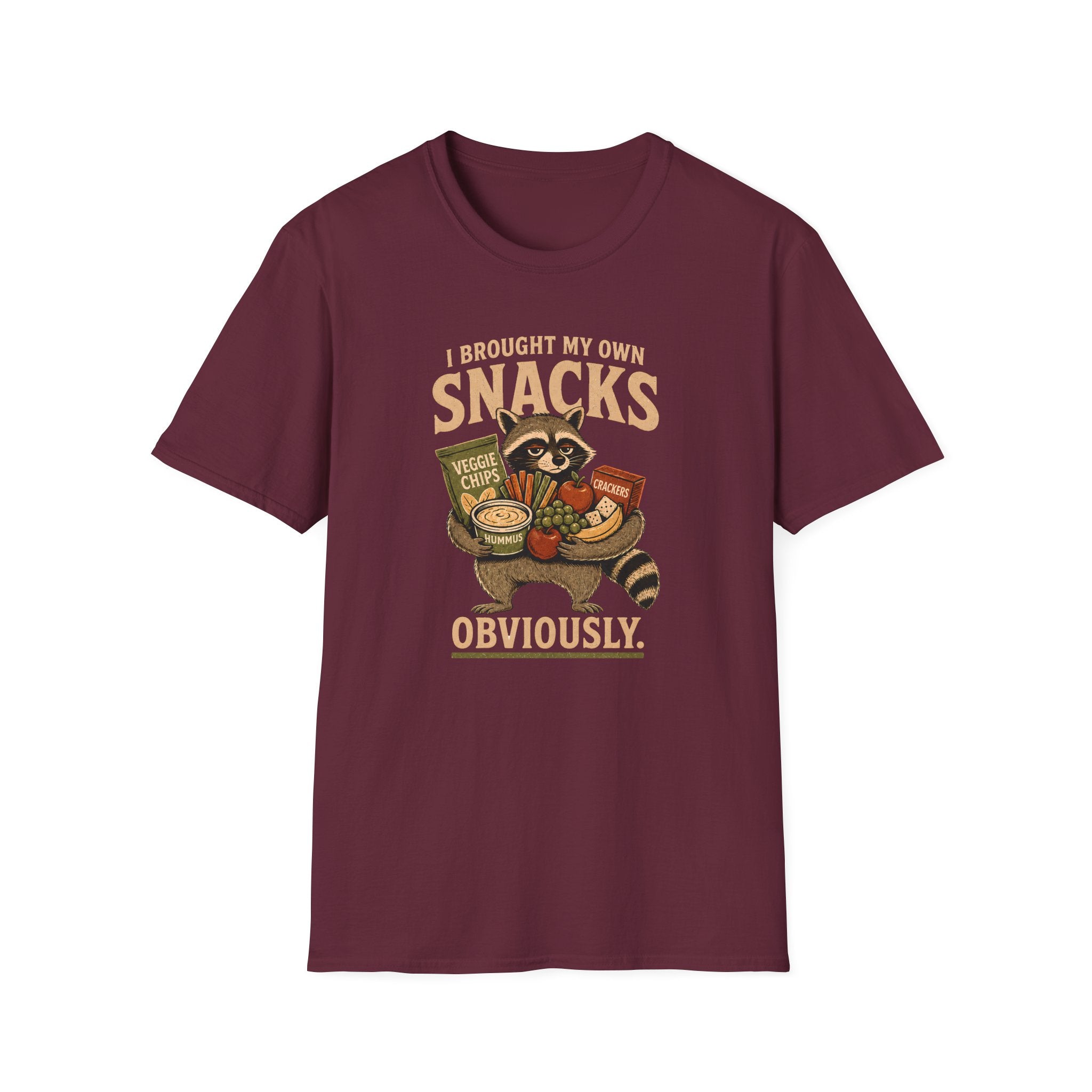 A maroon short-sleeve crewneck t-shirt featuring a vintage-style graphic of a raccoon holding a basket of snacks with the text 'I BROUGHT MY OWN SNACKS OBVIOUSLY.' printed on the front.