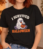 A woman with red hair wearing a black graphic t-shirt that reads 'I SURVIVED HALLOWEEN' with a ghost and pumpkin design, posed in a cozy, warmly lit autumn-themed room.