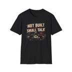 A black short-sleeve crewneck t-shirt with a graphic print on the front. The graphic features the text 'NOT BUILT FOR SMALL TALK' in distressed beige and red lettering above a dark, moody city street scene at night with a red neon sign.