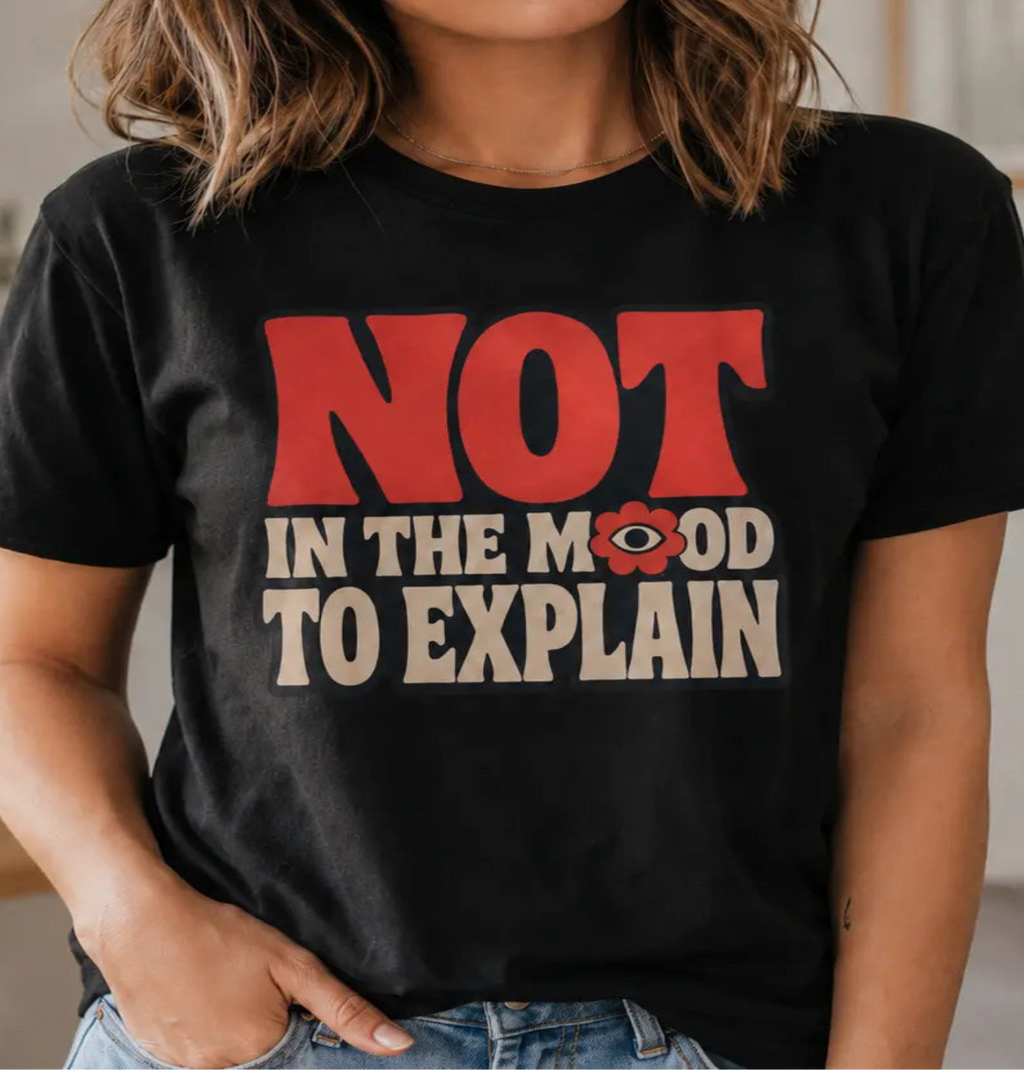 Woman wearing a black t-shirt with the words 'not in the mood to explain'