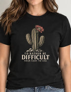 woman wearing a black short-sleeve crewneck t-shirt featuring a graphic of a cactus with a flower and the text 'I'D RATHER BE DIFFICULT THAN EASY TO USE' printed on the front, displayed against a solid white background.