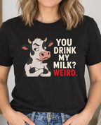 woman wearing a black t-shirt with a cow graphic and text 'you drink my milk? weird'