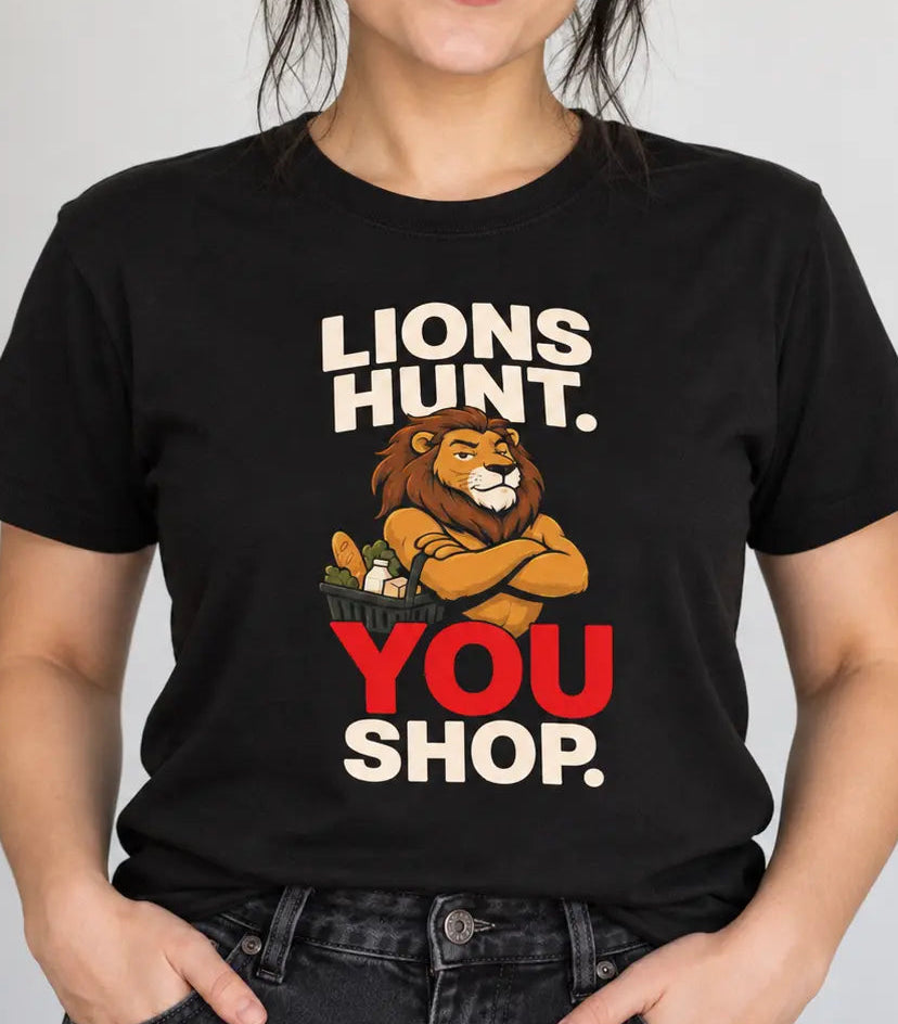 A woman wearing a black graphic t-shirt with a cartoon lion and the text 'LIONS HUNT. YOU SHOP.