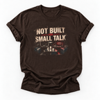 A dark brown short-sleeve t-shirt with a distressed graphic on the front that reads 'NOT BUILT FOR SMALL TALK' above a control room scene, displayed on a clean white background.
