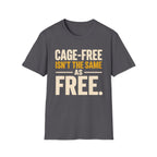 A charcoal short-sleeve t-shirt with a graphic text print reading 'CAGE-FREE ISN'T THE SAME AS FREE.' in cream and mustard yellow lettering, displayed on a solid white background.