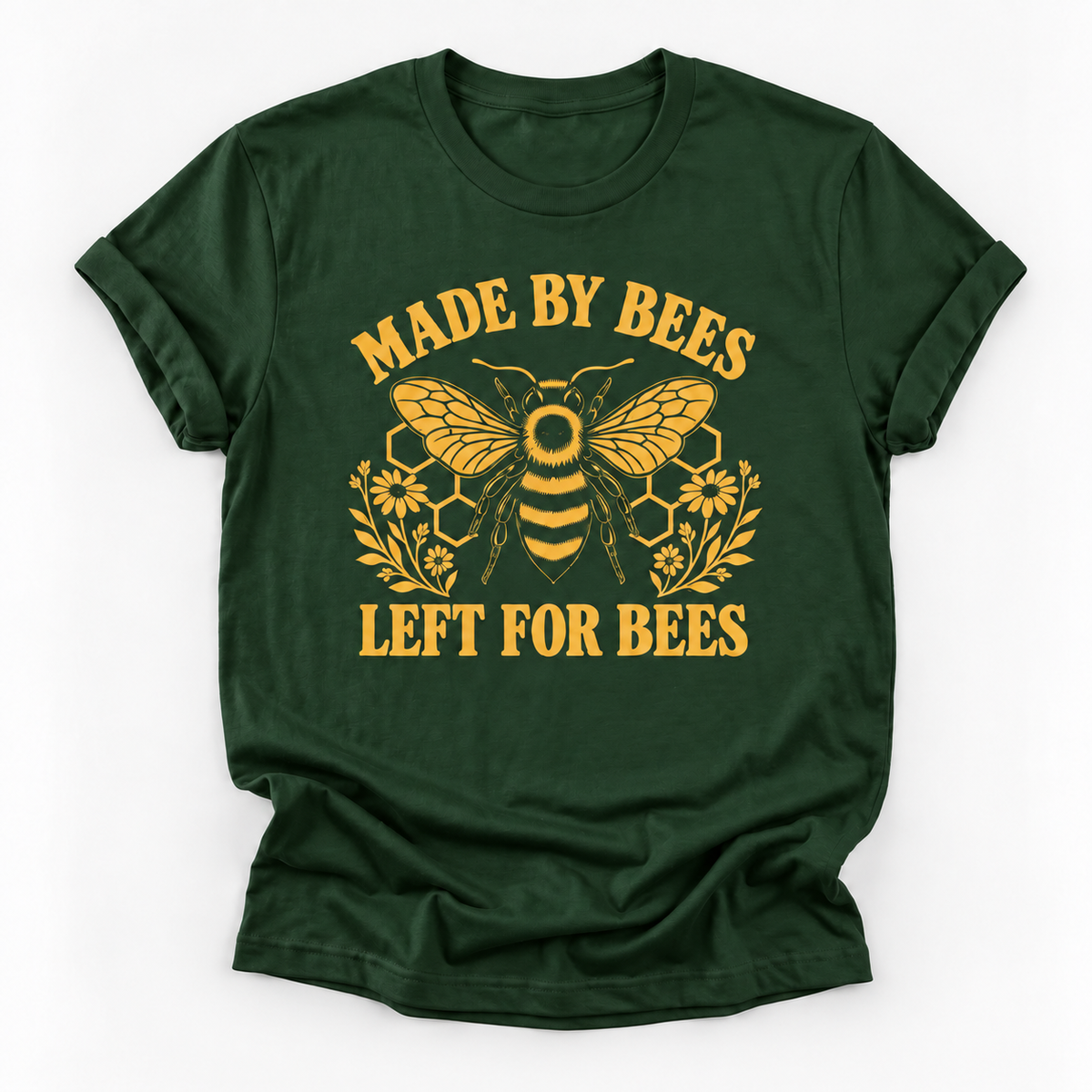 A dark green short-sleeve t-shirt with a yellow graphic print featuring a bee, honeycomb, flowers, and the text 'MADE BY BEES LEFT FOR BEES' on a white background.