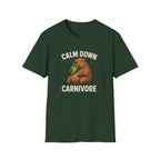 Green vegan short-sleeve crewneck t-shirt featuring a cartoon graphic of a brown groundhog holding green lettuce, with the text 'CALM DOWN CARNIVORE' printed in beige above and below the illustration.