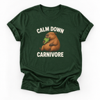 A dark green short-sleeve t-shirt with a graphic of a capybara eating leafy greens, surrounded by the text 'CALM DOWN CARNIVORE' in white. The t-shirt is displayed flat against a clean white background.