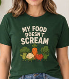 Woman wearing a forest green t-shirt with vegetable characters and text 'my food doesn't scream"