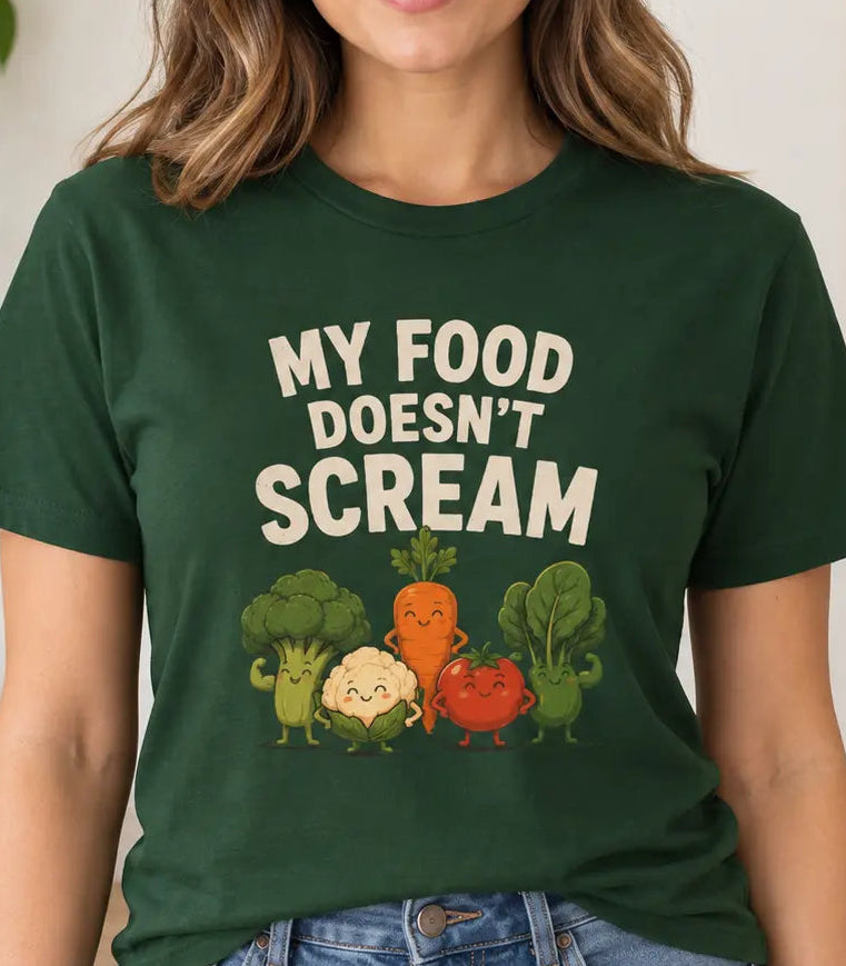 Woman wearing a forest green t-shirt with vegetable characters and text 'my food doesn't scream"