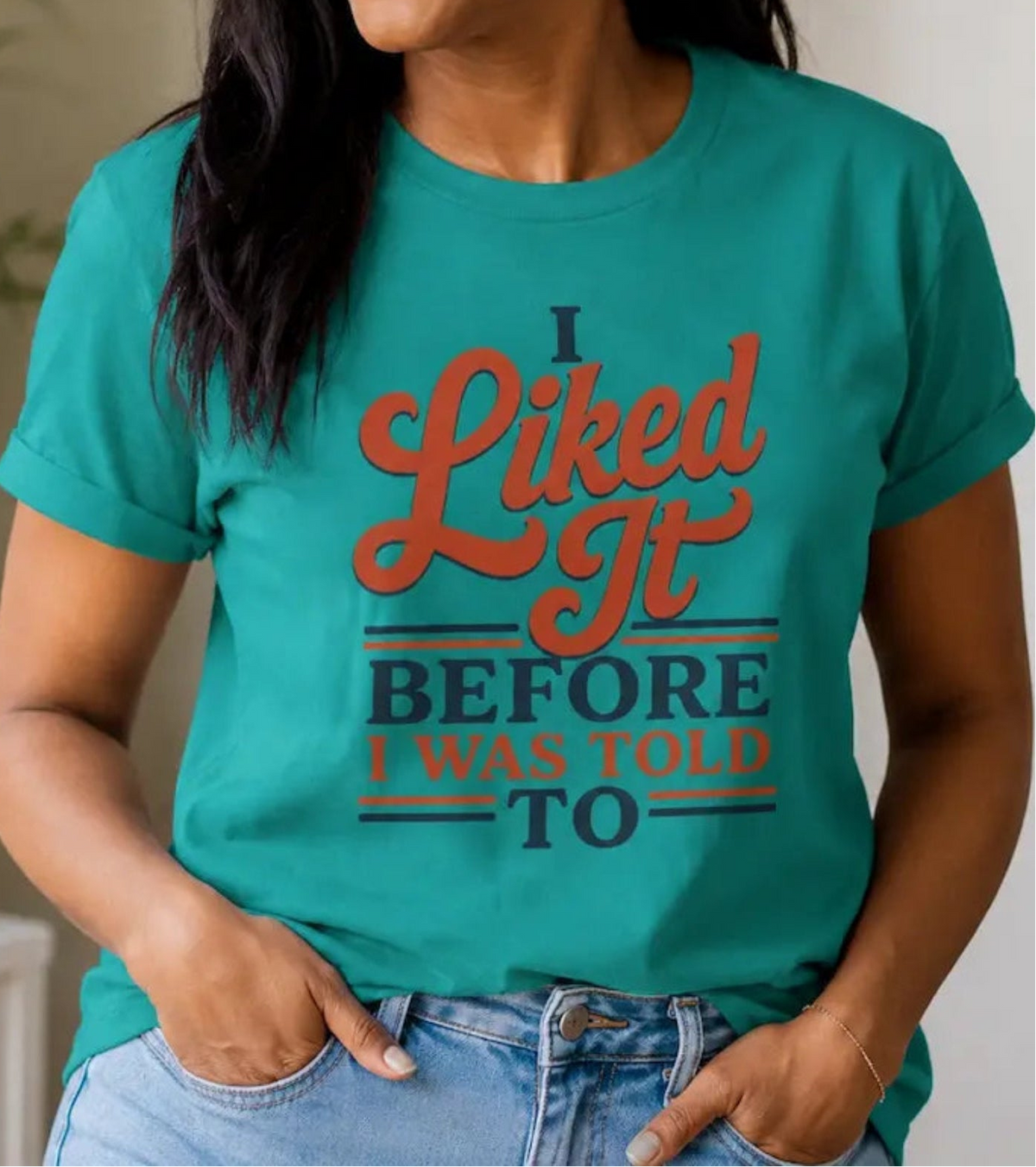 Woman wearing a green t-shirt with the  words 'i liked it before i was told to'