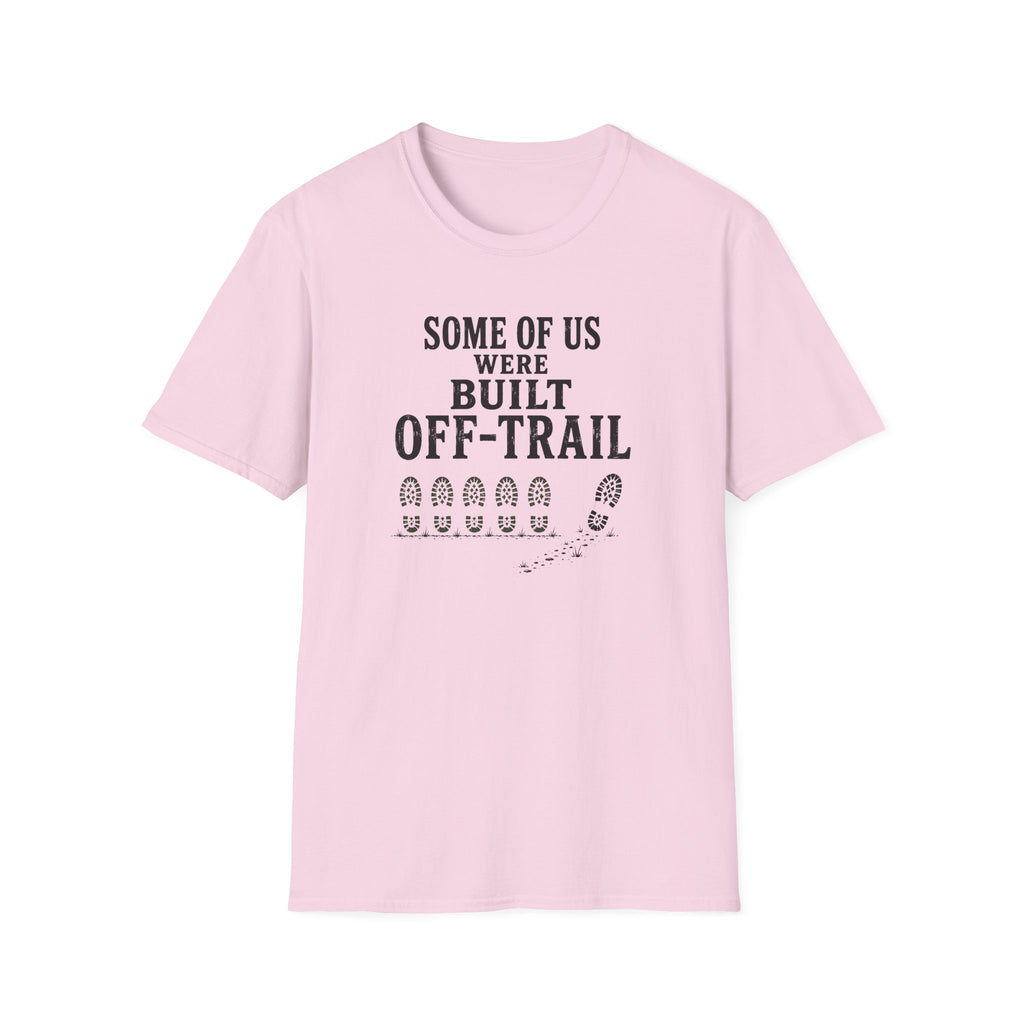 A light pink short-sleeve crewneck t-shirt with a black graphic print on the front that reads 'SOME OF US WERE BUILT OFF-TRAIL' above a row of boot prints and a trail graphic.
