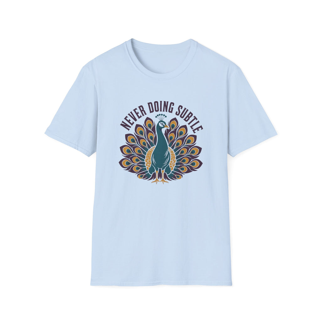 A light blue short-sleeve crewneck t-shirt featuring a graphic of a teal peacock with its tail feathers fanned out, under the text 'NEVER DOING SUBTLE' 