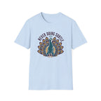 A light blue short-sleeve crewneck t-shirt featuring a graphic of a teal peacock with its tail feathers fanned out, under the text 'NEVER DOING SUBTLE' 