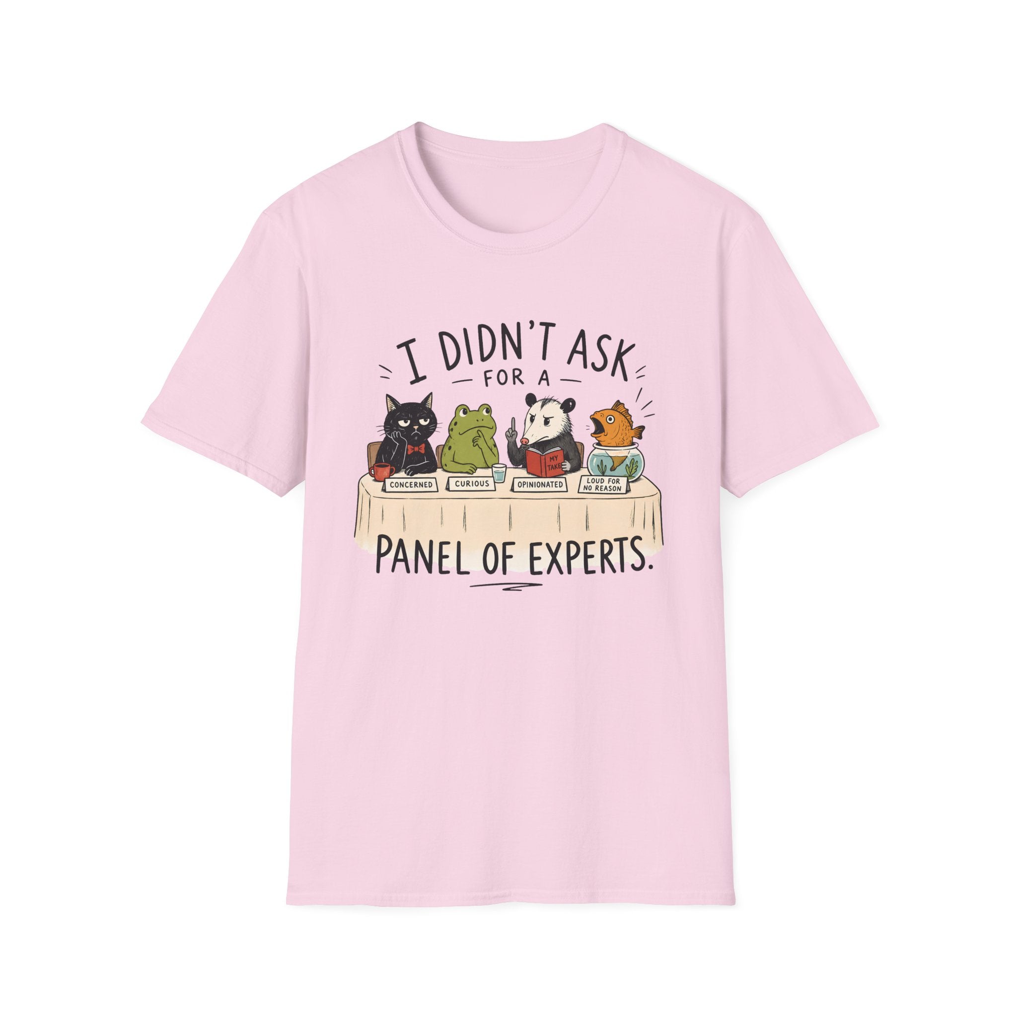 A light pink short-sleeve crewneck t-shirt featuring a cartoon graphic of five animals (a cat, frog, panda, and two birds) sitting on books, with the text 'I DIDN'T ASK FOR A PANEL OF EXPERTS.' printed above and below.