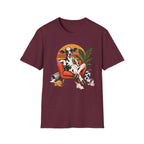 A maroon short-sleeve crewneck t-shirt featuring a colorful graphic print of a cow lounging in an orange armchair against a sunset background.