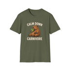 An olive green short-sleeve t-shirt with a graphic of a brown capybara holding green leaves, with the text 'CALM DOWN CARNIVORE' in beige above and below the illustration, displayed on a solid white background.