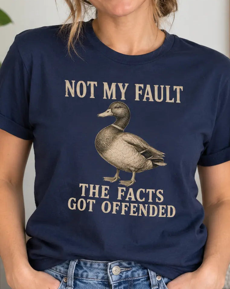 Woman wearing a navy blue t-shirt with a duck graphic and text 'not my fault the facts got offended'