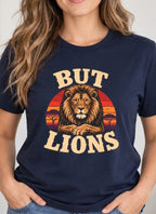 Woman wearing a navy blue t-shirt with a lion graphic and sunset and text 'but lions'