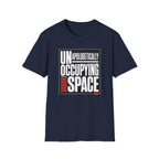 A navy blue short-sleeve t-shirt with a graphic print on the front reading 'UNAPOLOGETICALLY OCCUPYING SPACE' in white and red text inside a black rectangular border, shown on a plain white background.