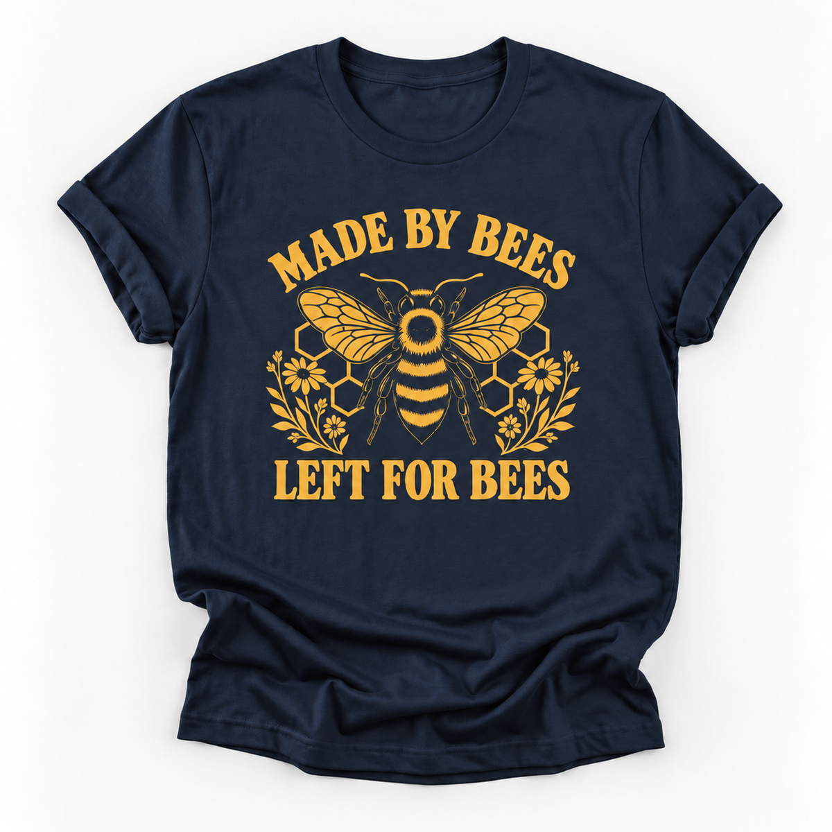 A navy blue short-sleeve t-shirt with a yellow graphic print featuring a bee, honeycomb, flowers, and the text 'MADE BY BEES LEFT FOR BEES' on a white background.