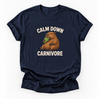A navy blue short-sleeve t-shirt with a graphic of a capybara eating green leaves, surrounded by the text 'CALM DOWN CARNIVORE' in cream lettering, shown on a plain white background.