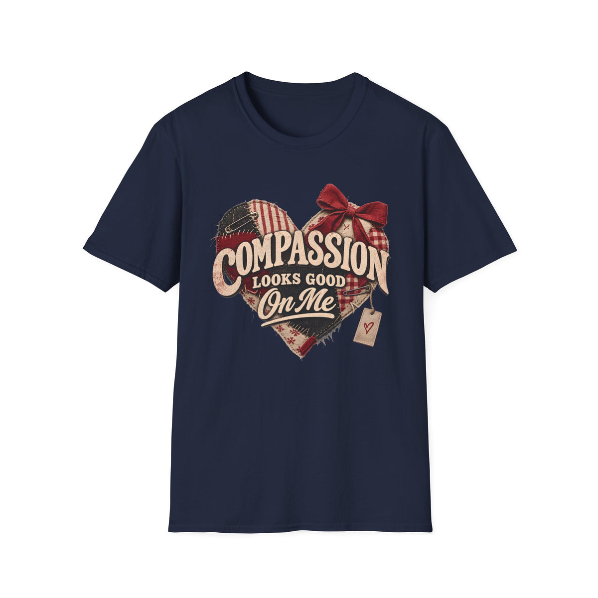 A navy blue short-sleeve crewneck t-shirt featuring a distressed graphic on the front. The graphic shows a heart made of red and white gingham patterns, with a red bow on top, and the text 'COMPASSION LOOKS GOOD On Me' in a rustic cream font.