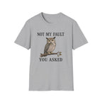 A Grey graphic t-shirt laid flat on a wooden surface, styled with blue jeans, white sneakers. The t-shirt features a graphic of a owl perched on a branch with the text 'NOT MY FAULT YOU ASKED' in black.