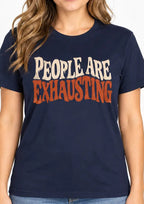 woman wearing a Navy Blue t-shirt with Distressed retro typography design reading “People Are Exhausting” in cream and burnt orange with drooping, tired-looking letterforms.