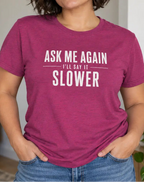 Woman wearing a pink t-shirt with text 'ask me again i'll say it slower'