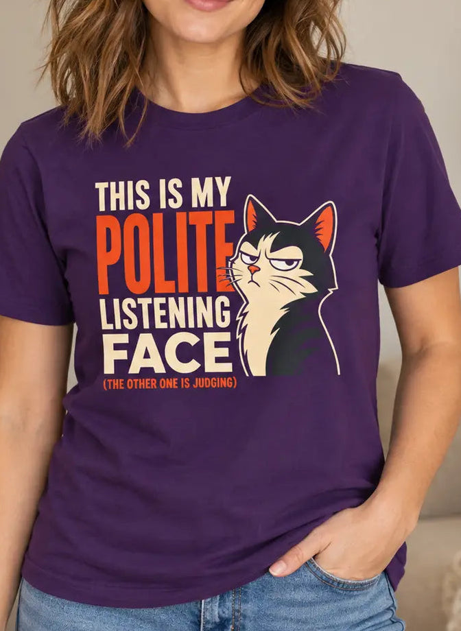 A woman wearing a purple graphic t-shirt with a cat illustration and the text 'THIS IS MY POLITE LISTENING FACE'.